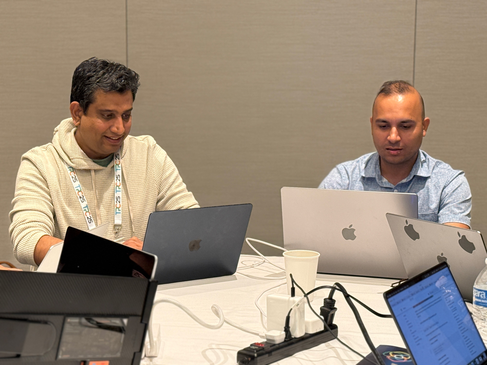 TCP attendees working side-by-side on their laptops.